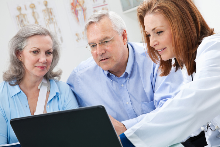 doctor and patients looking at laptop