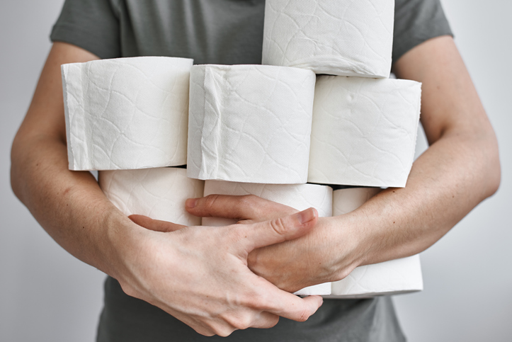 person holding many rolls of toilet paper
