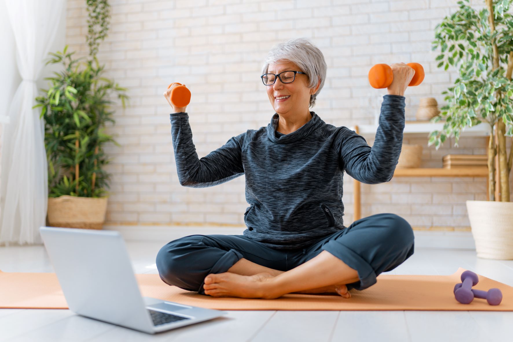 Woman exercising with laptop in front