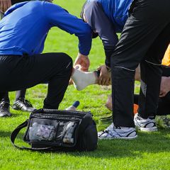 Injured football played getting treated by medical staff on field.