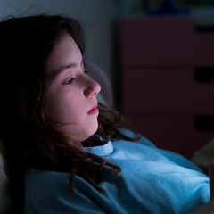 Teen girl lying in bed on phone