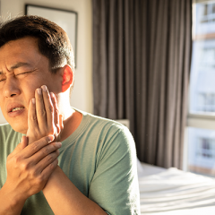 Man holding jaw with pained expression