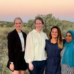 a group of women standing together in a field