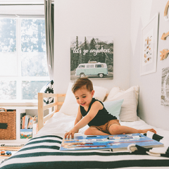 Child reading book on bed in bedroom
