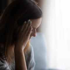 woman with hand on face