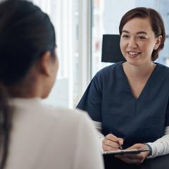 Female nurse talking to young patient