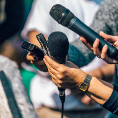 Journalist hands holding microphones at press conference