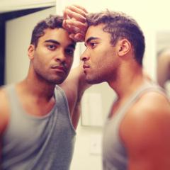 sad man looking in mirror