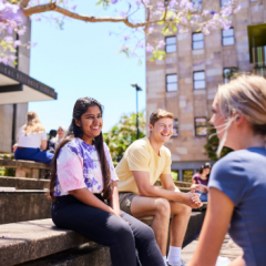 Three students sitting on campus