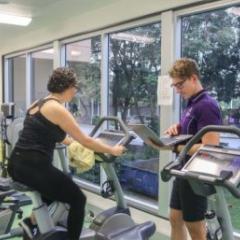 Participant on exercise bike supervised by UQ staff