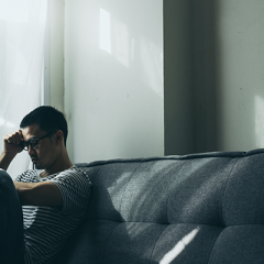 Man sitting on couch looking anxious