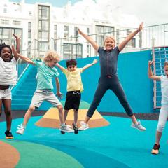Children happily jumping around on playground equipment.