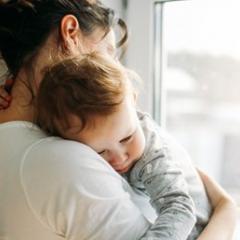 Mother cuddling young child. 