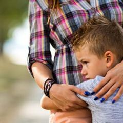 young boy hugging mother 
