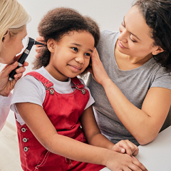 young girl getting hearing checked with mother