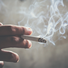 Person holding a smoking cigarette 