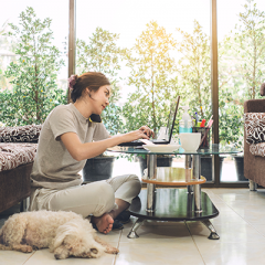 Woman sitting on floor working from home on a phone call