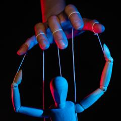 hand controlling a mannequin like a puppet