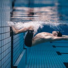 Pro male swimming turning under water 