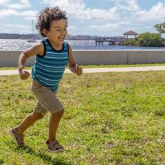 Young child running on grass smiling