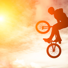 BMX rider airborne in front of sunset sky