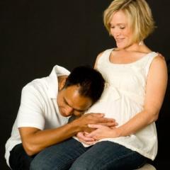 man with his head on his partner's pregnant belly