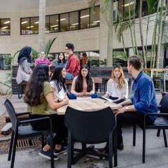 a group of psychology sitting around a table in a courtyard