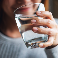 Woman holding glass of water to mouth