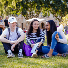 Three UG students sitting on grass area