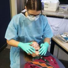 Queensland Health Oral Health Therapist Amy Thomas checks the teeth of Eagleby State School student