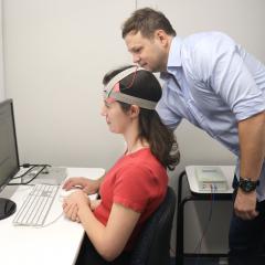 UQ researcher conducting multitasking training and brain stimulation with a participant