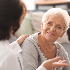 Doctor talking to elderly patient who is smiling