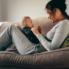 Mother talking to baby on couch 