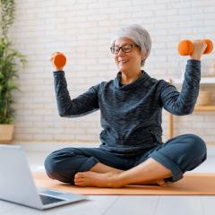 Woman exercising with laptop in front 
