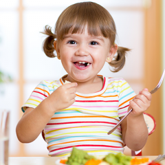 Young girl eating vegetables 