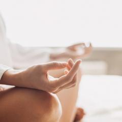 close up image of hands on crossed legs in a meditation pose 