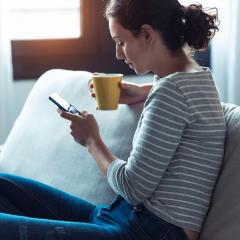woman on couch looking at phone
