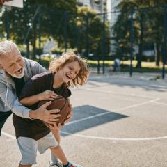 older person playing basketball with a younger person